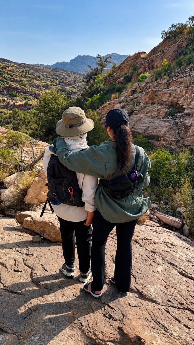 Two women with their arms around each other on a rocky mountain trail